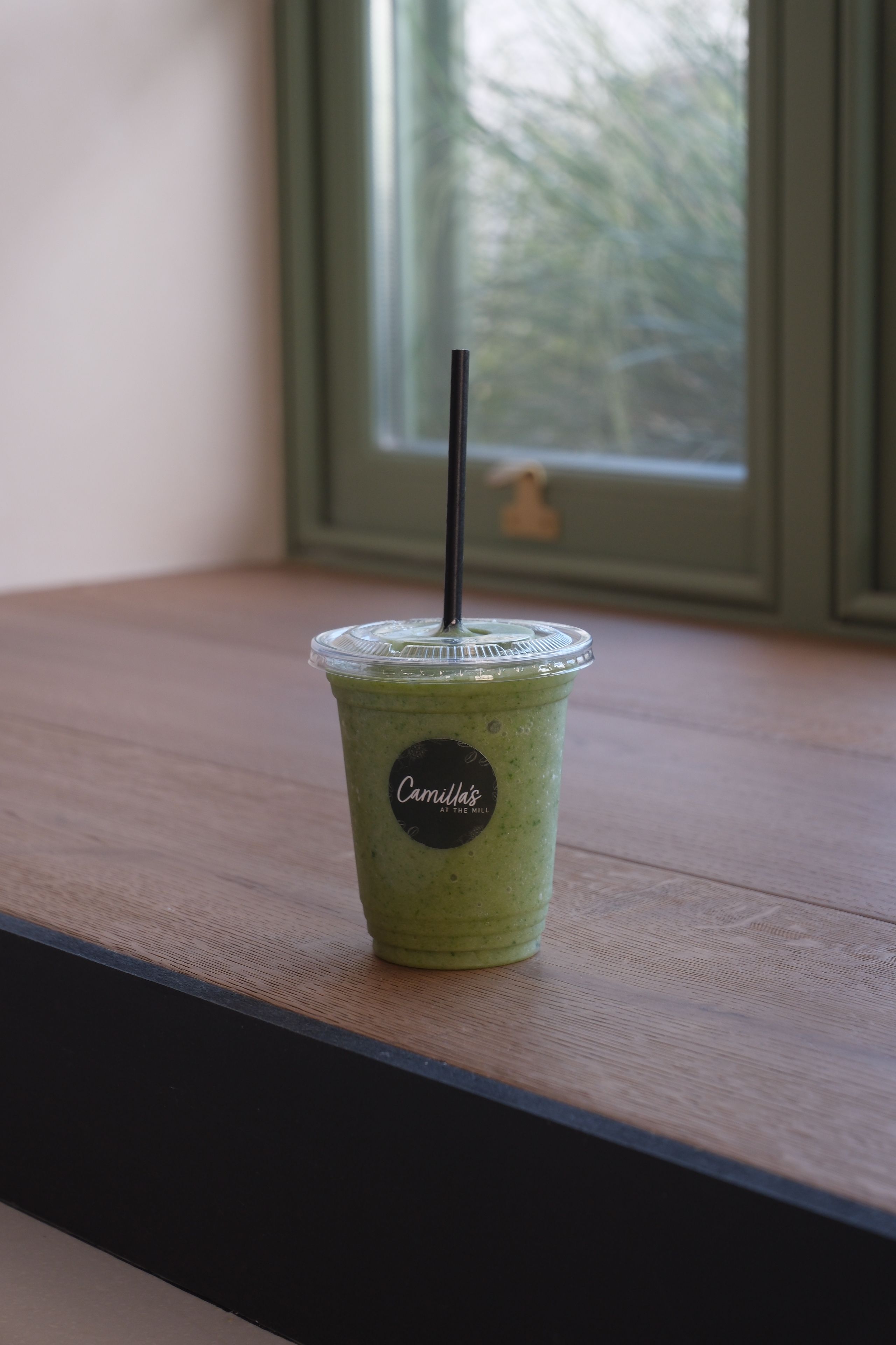 A green matcha smoothie in a glass