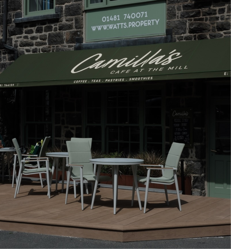 Camilla's Cafe at the Mill with a green awning and outdoor seating on a wooden deck.