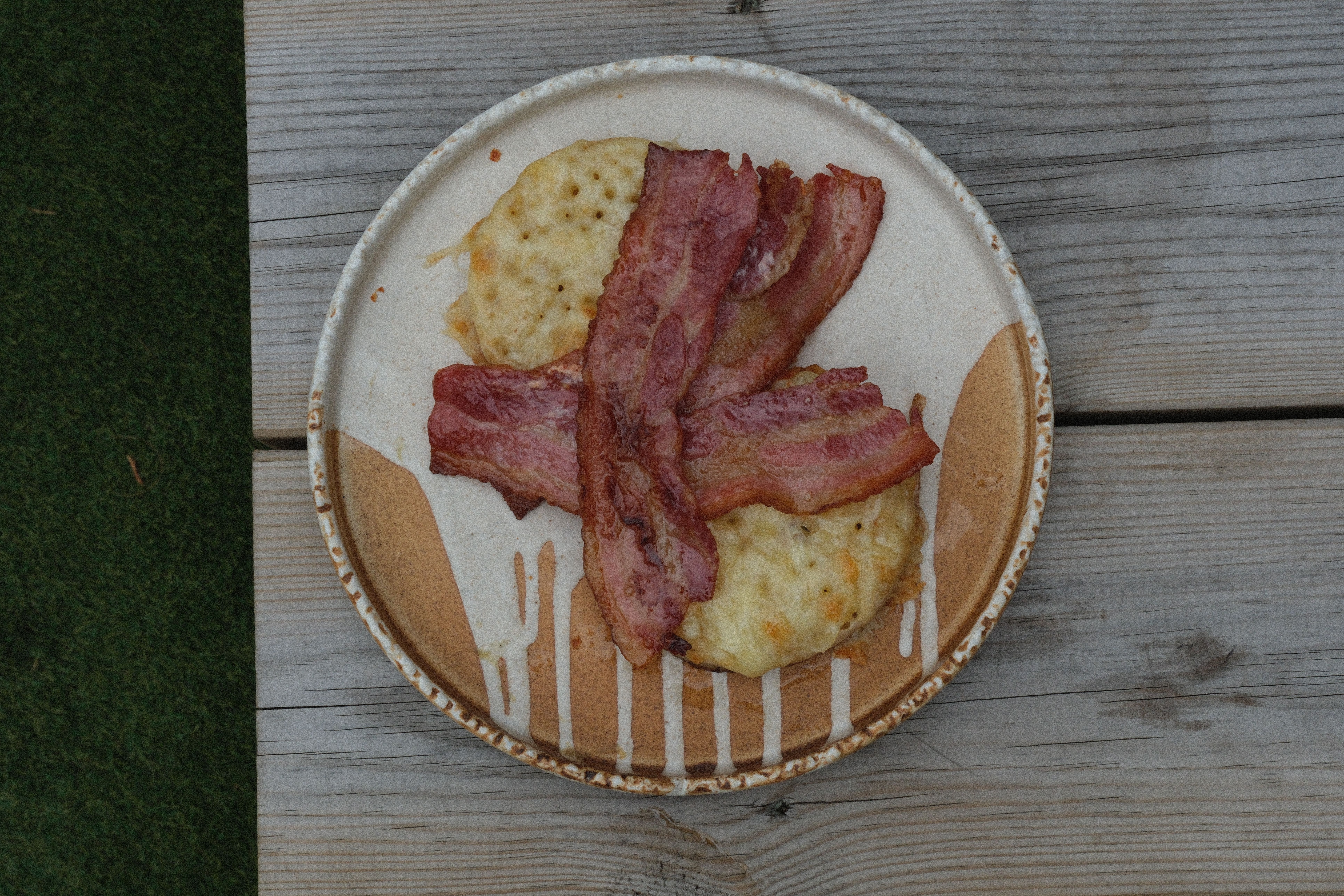 Crispy bacon and cheesy biscuits on a patterned plate.