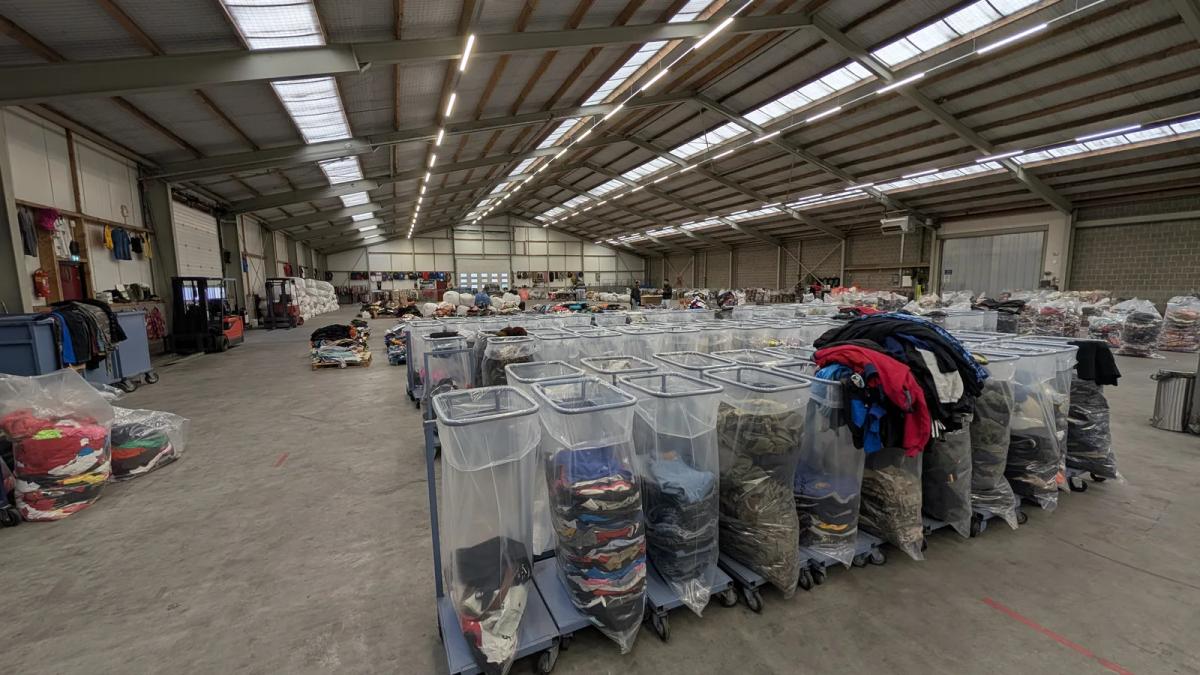 Voorgesorteerde workwear-balen op een rek in het magazijn van Excellent Vintage in Bovenkarspel