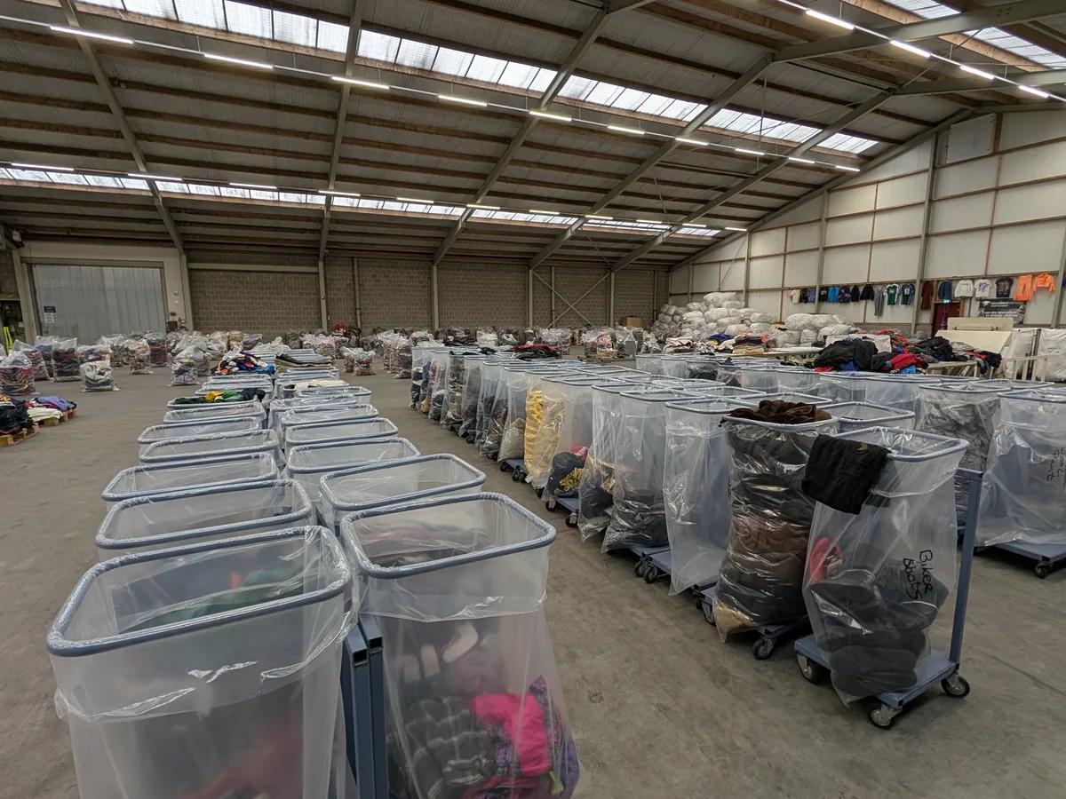 Overzicht van de warehousevloer met balen tweedehands kleding in Bovenkarspel