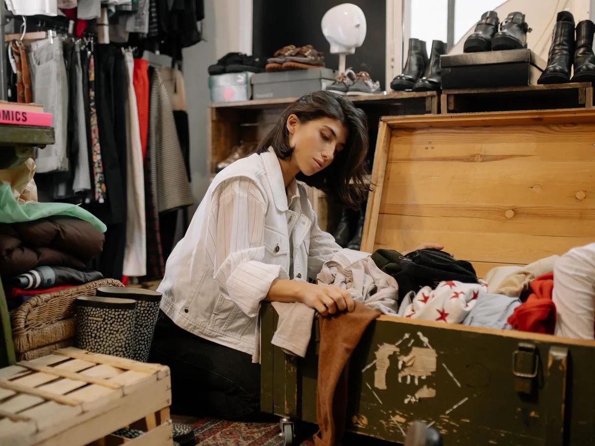 Reseller sorting a pile of secondhand clothing by quality