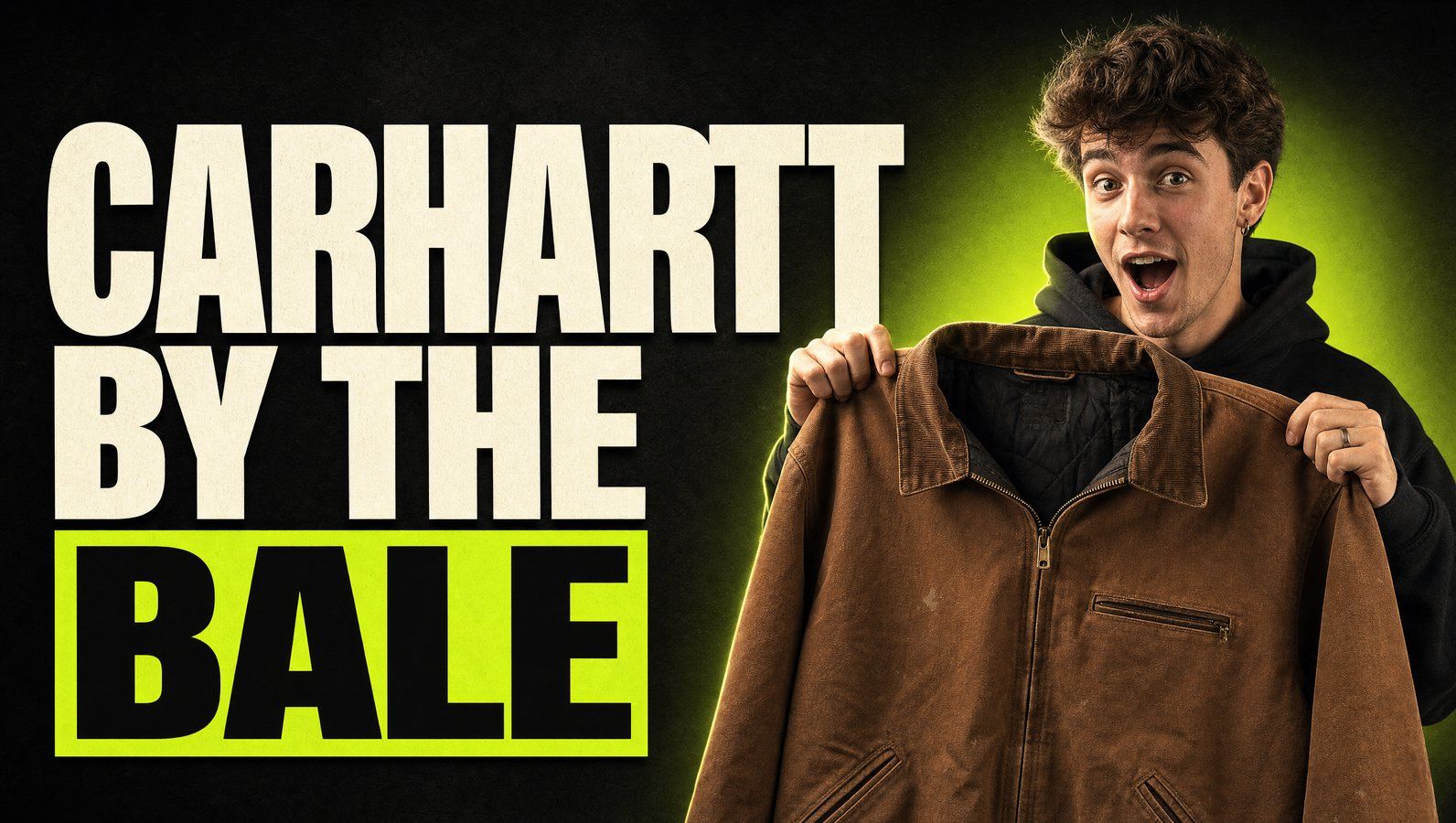 Young reseller holding a vintage Carhartt Detroit jacket — buying Carhartt by the bale at Excellent Vintage