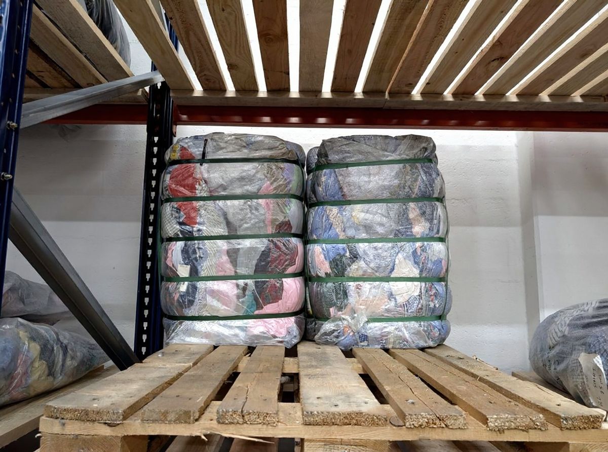 Close-up van een opengemaakt tweedehands kleding bale met gesorteerde kledingstukken uit het warehouse in Bovenkarspel