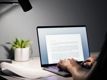 Laptop with person writing content