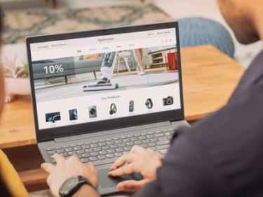 Male using laptop to browse a website with discounted appliances