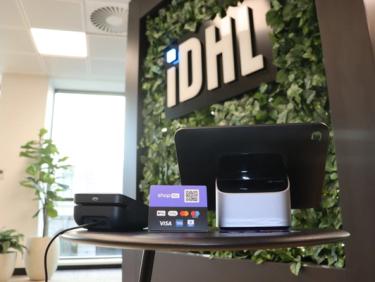 Shopify POS system placed in front of IDHL logo