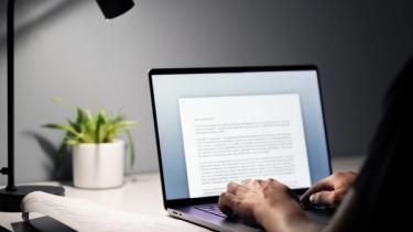 Laptop with person writing content