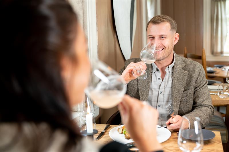 Mann og kvinne som skåler ved bordet