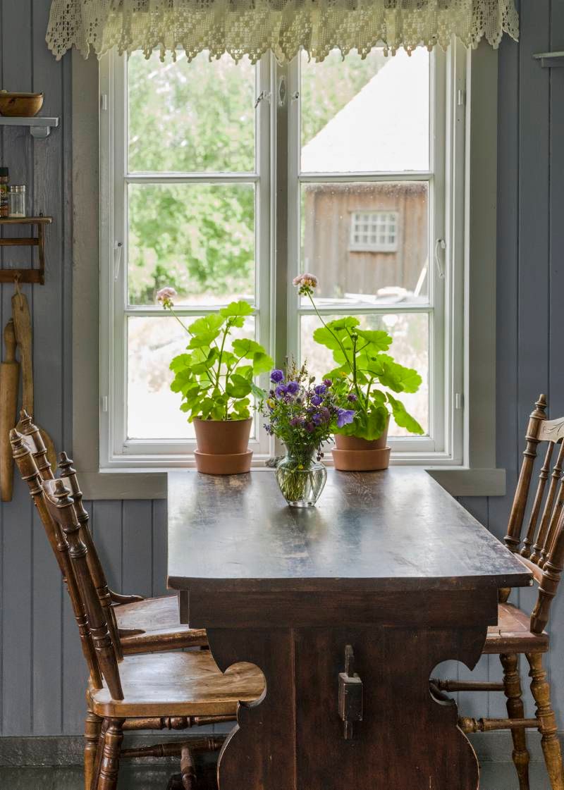 en spisestue dekorert med blomster ved et vindu