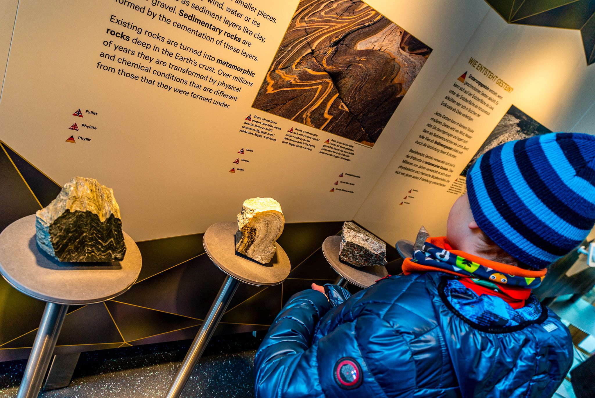 A child looking at different types of rocks in the geolocial section of the exhibition.