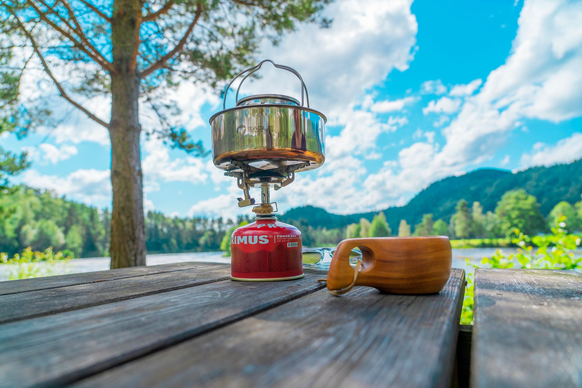 Kaffekopp og primus på et bord ute på Villmarkscamp