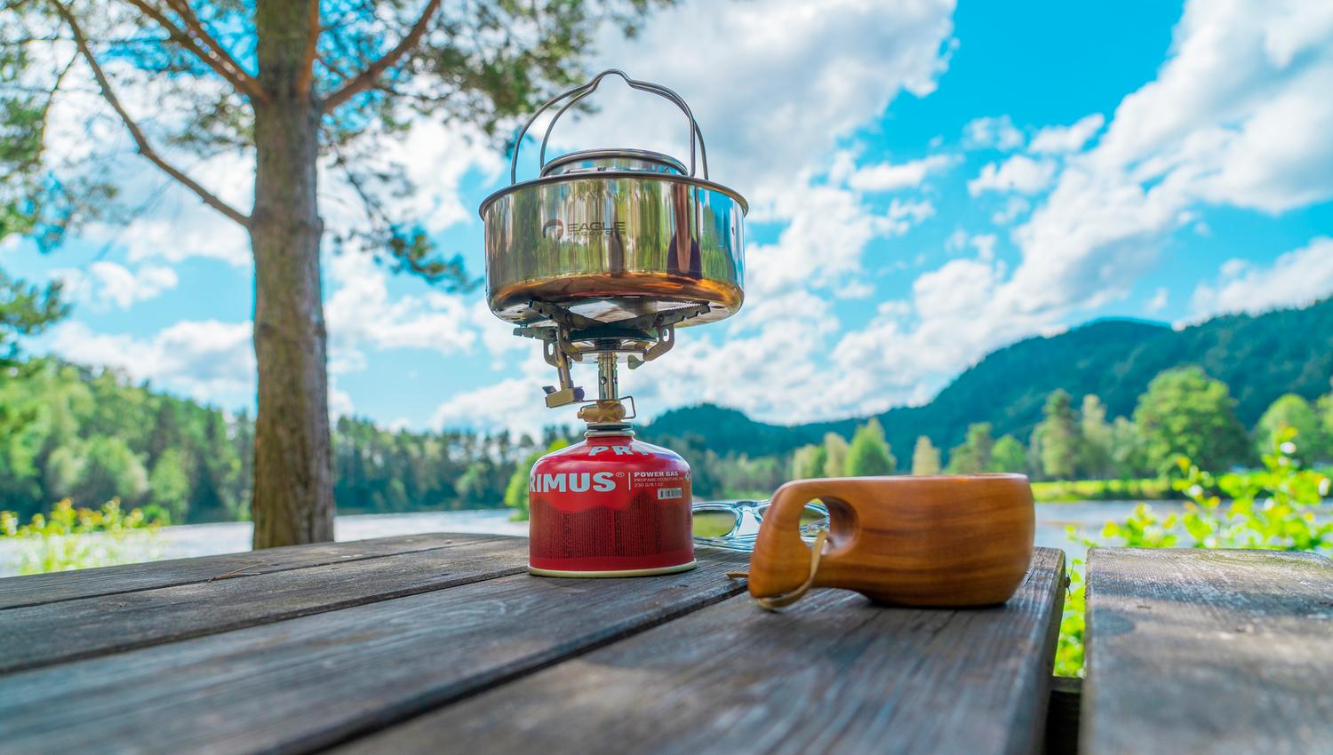 Kaffekopp og primus på et bord ute på Villmarkscamp