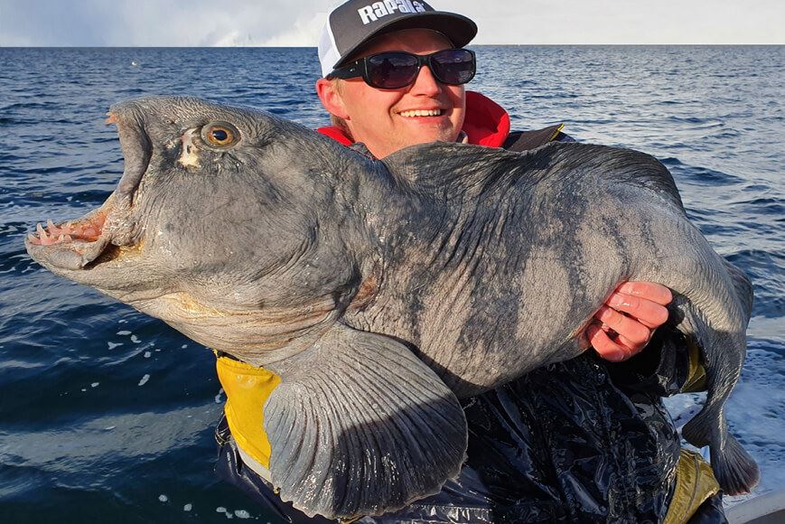Man holding a cat fish on a fishing trip with Explore the Arctic