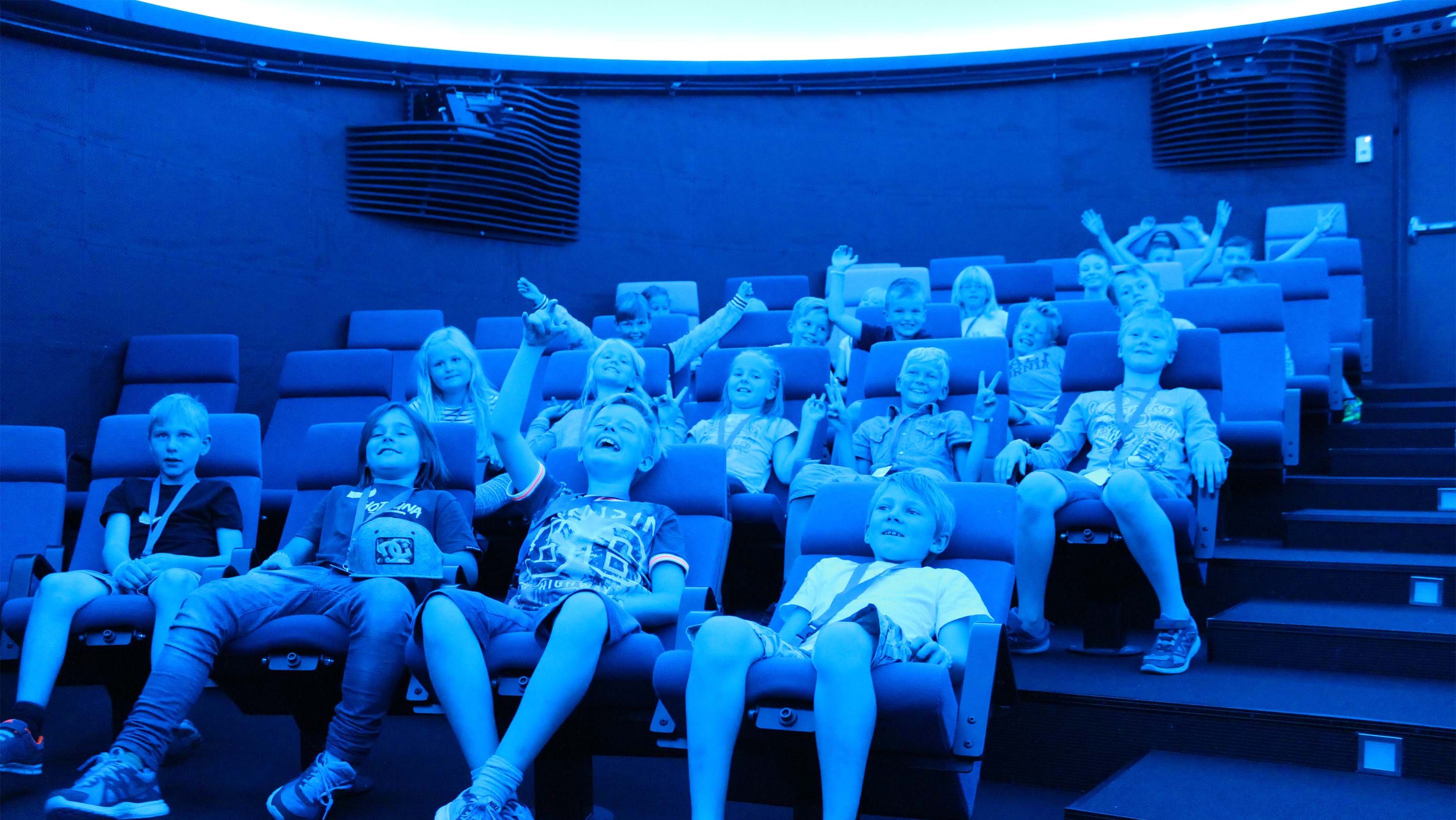 Happy children in the planetarium. Photo.