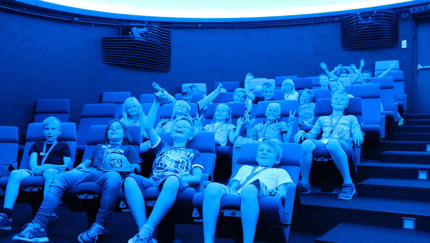 Happy children in the planetarium. Photo.