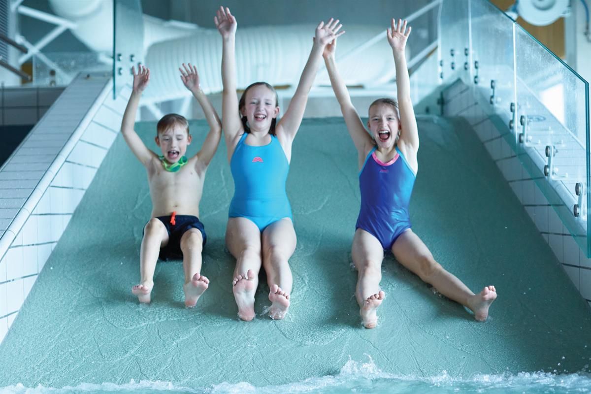 Sklie i Ankerskogen svømmehall. Tre glade barn