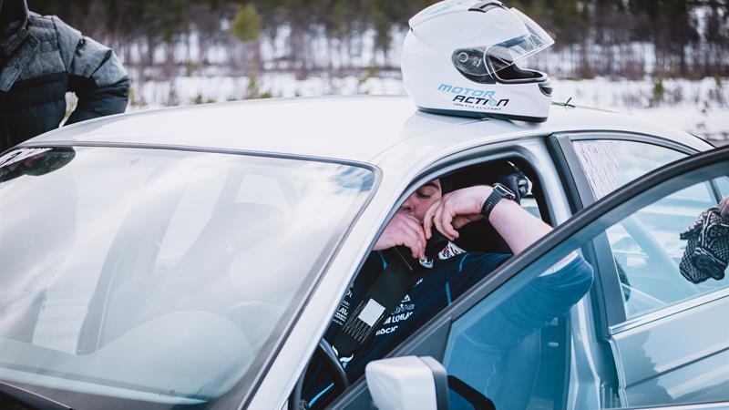 A driver is sitting in the car after an extreme rally experience