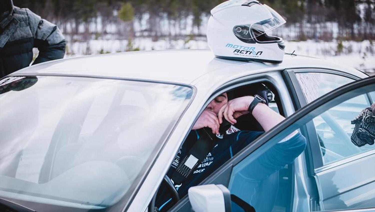 A driver is sitting in the car after an extreme rally experience