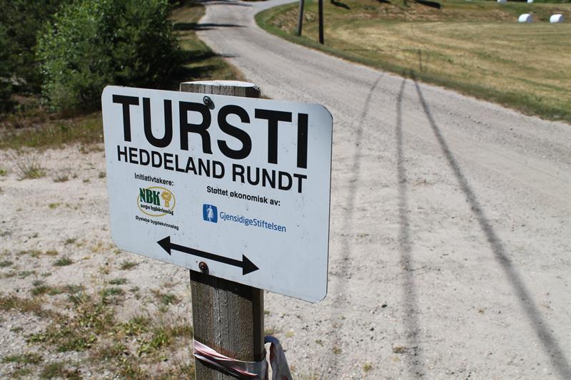 Bilde av skilt "Tursti, Heddeland rundt. Initiativtakere: NBK norges bygdekvinnelag. Øyslebø bygdekvinnelag. Støttet økonomisk av: GjensidigeStiftelsen."