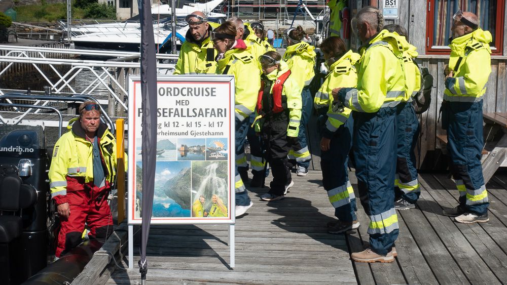 Turistar i klare gule drakter gjer seg klare til fjordcruise og fossefall-safari i Hardanger.