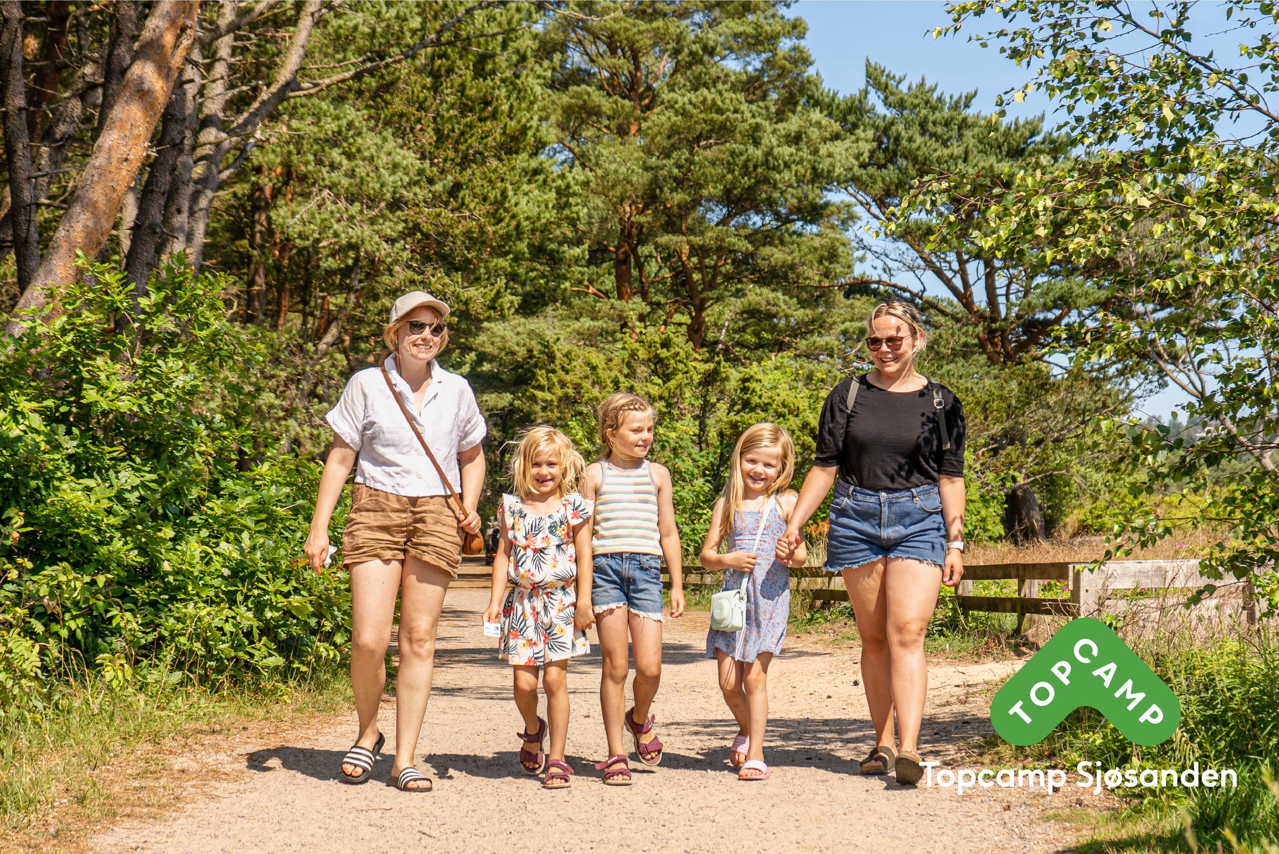 Familie på 5 som går gjennom skogen