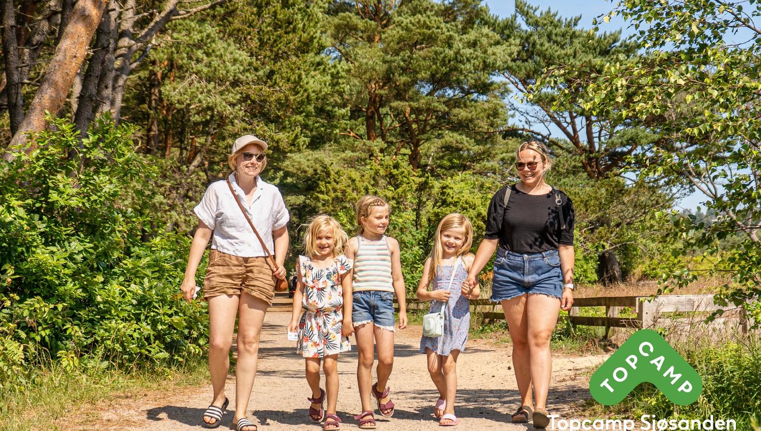 Familie på 5 som går gjennom skogen