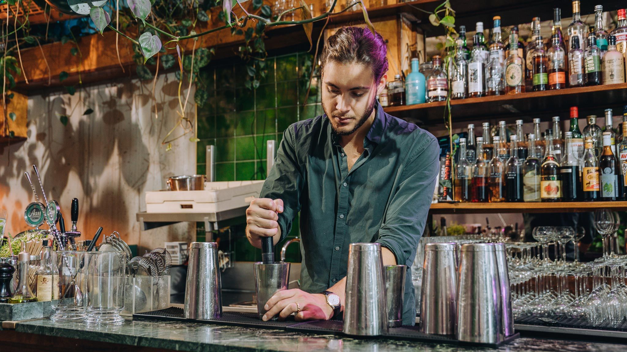 Bartender behind the bar mixing a drink