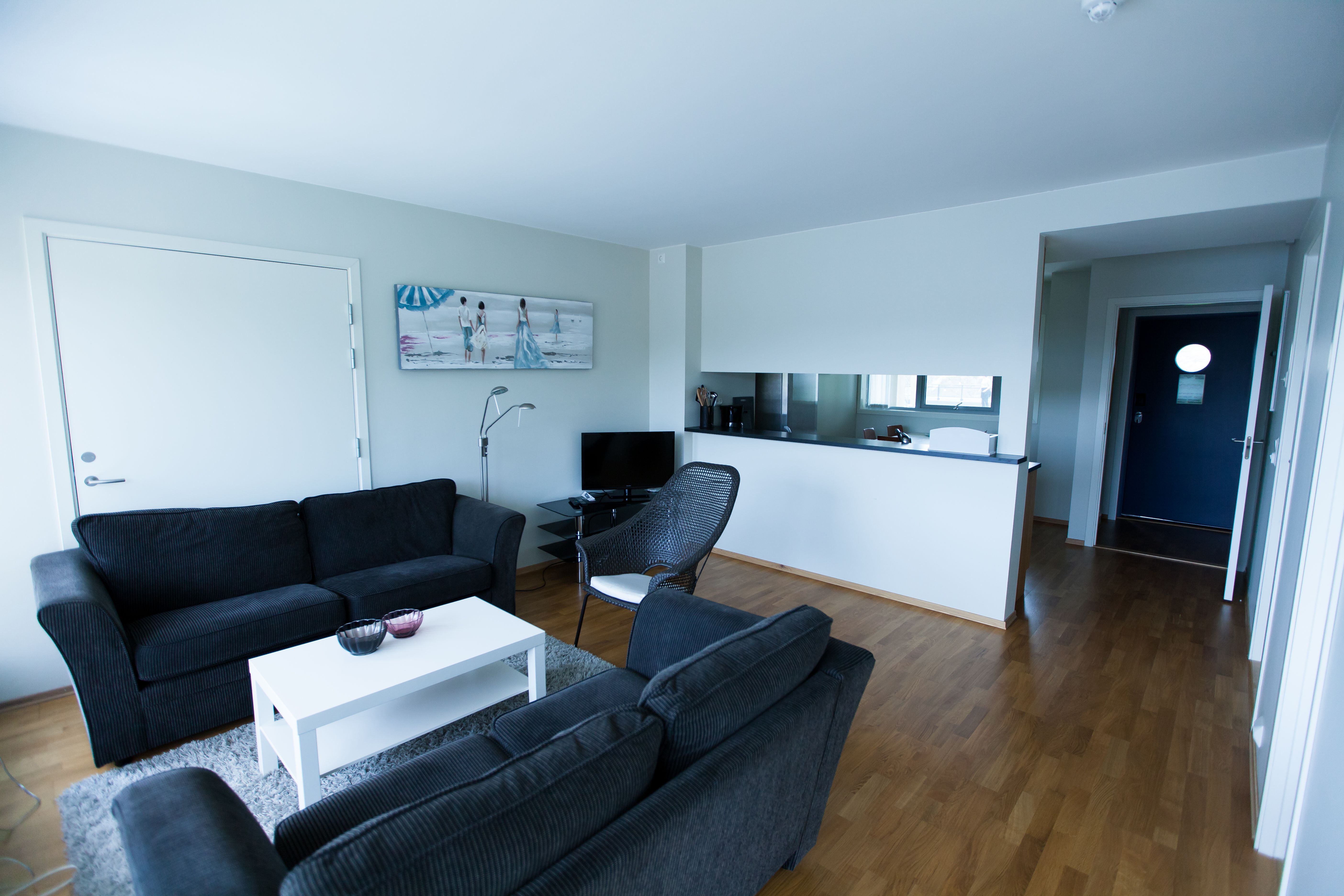 Lindesnes Havhotell – The living area of the hotel room, featuring a pair of black two-seater sofas.