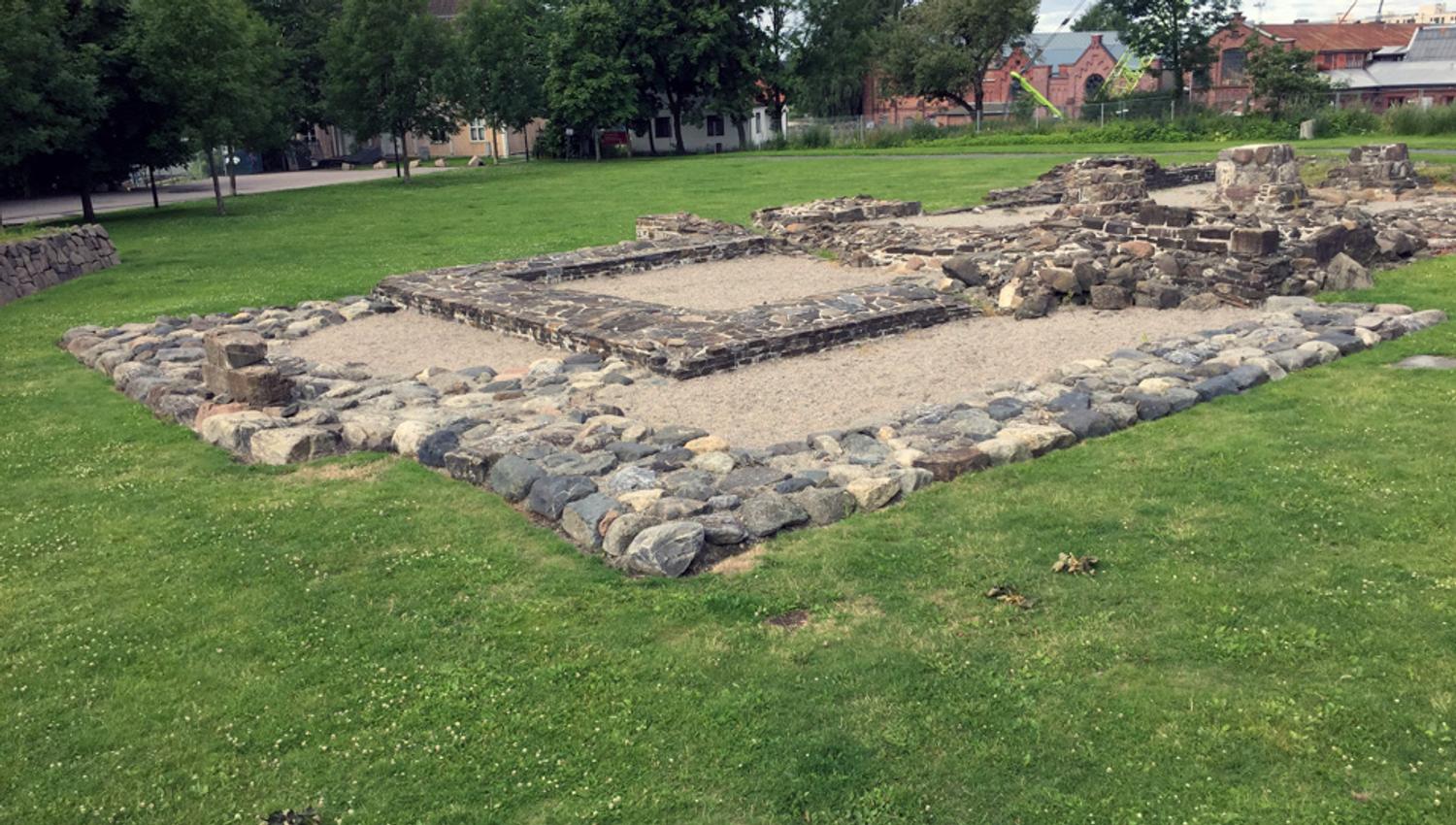 Steinruiner på en gressplen.