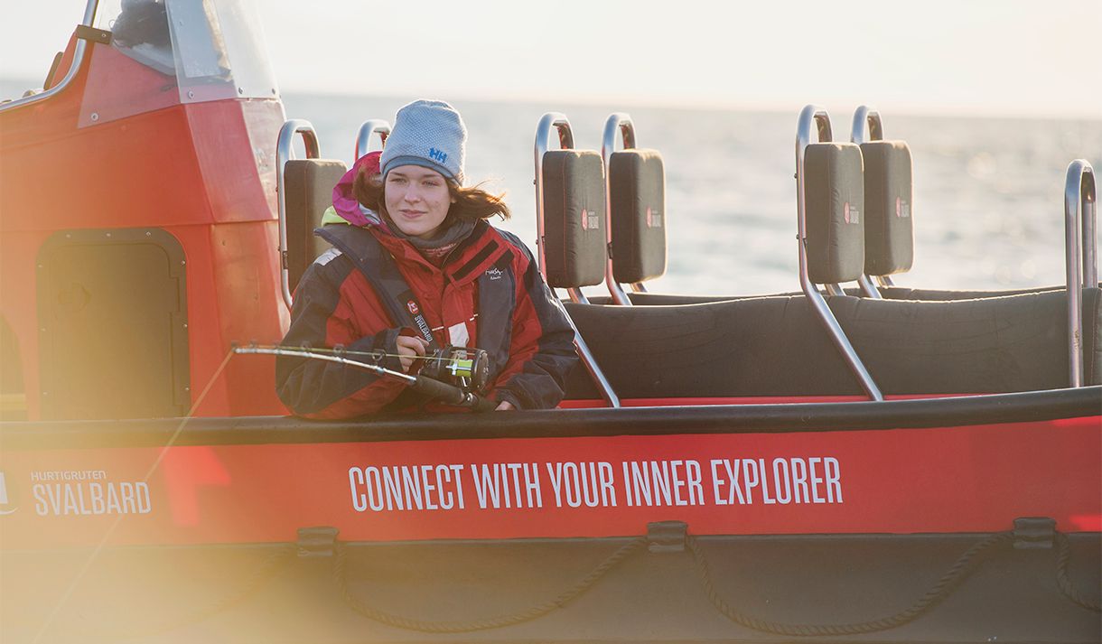 A guest sitting in a RIB boat fishing with a fishing pole from the boat