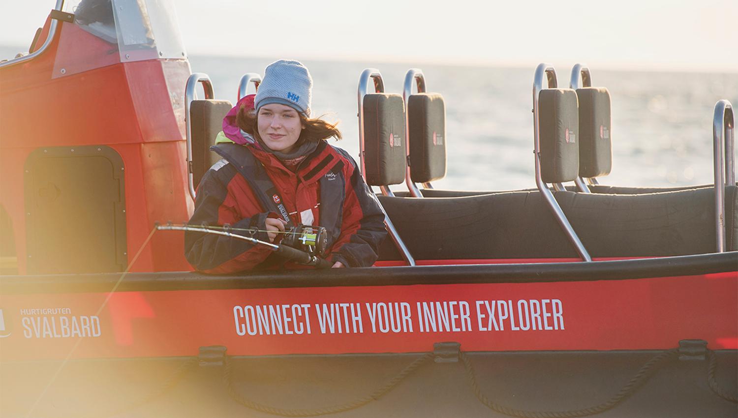 A guest sitting in a RIB boat fishing with a fishing pole from the boat