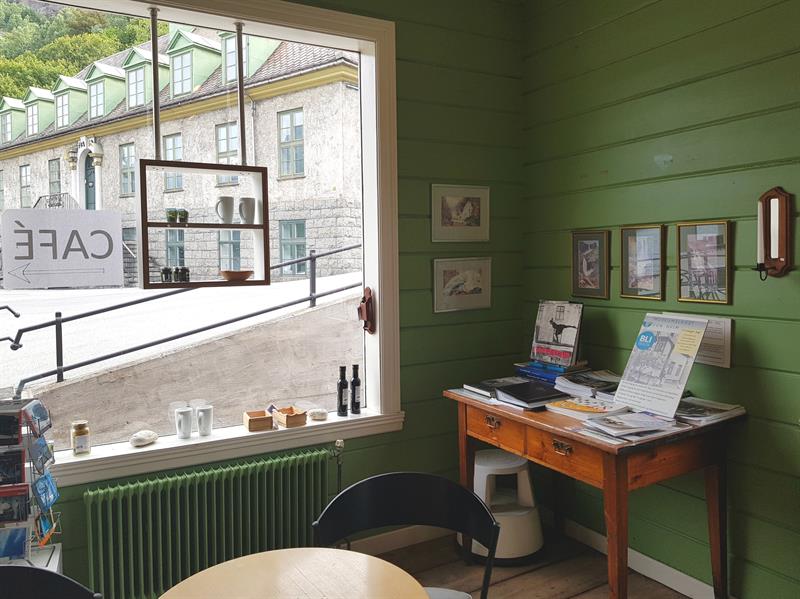 Kaféområde på Kraftmuseet, med utsikt mot museumsområdet og suvenirar tilgjengeleg for besøkande.