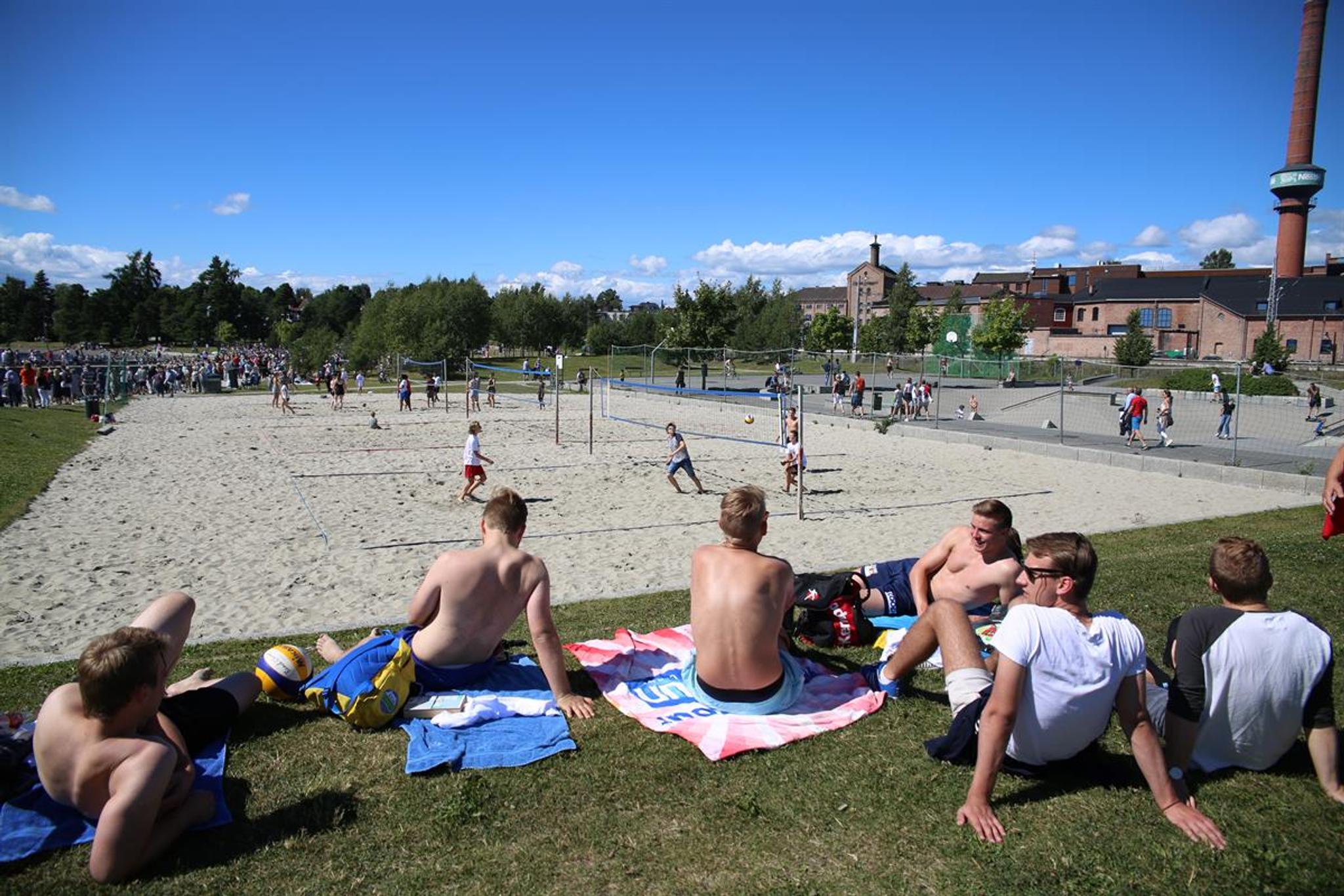 Beach volleyball court and youth sitting beside