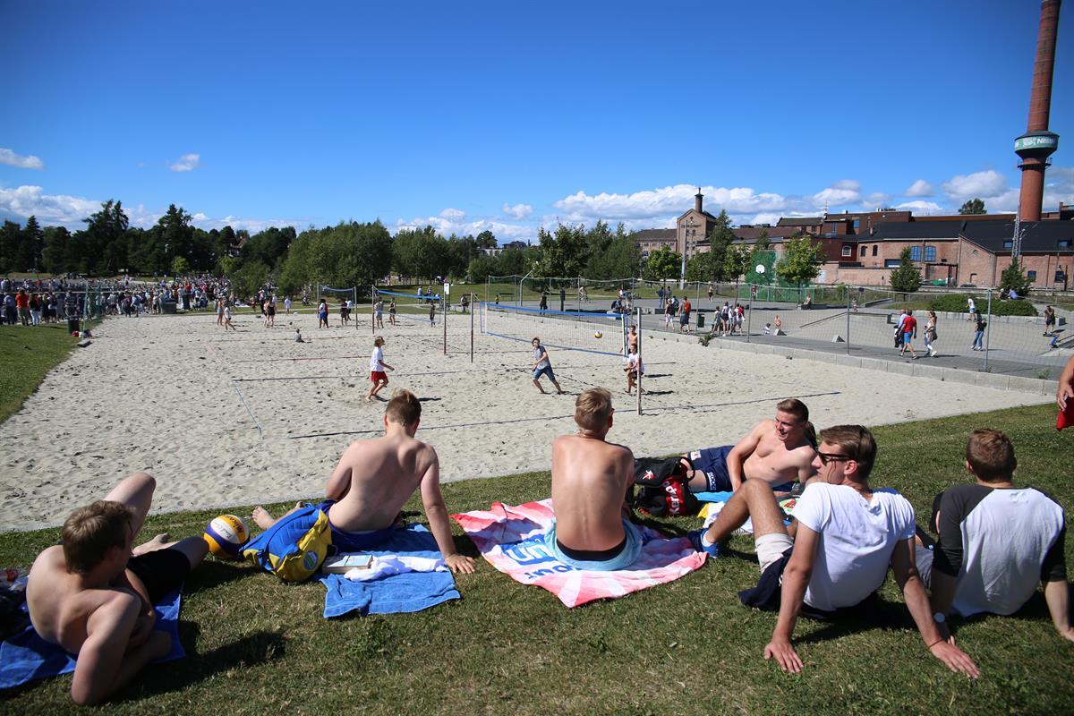 Beach volleyball court and youth sitting beside