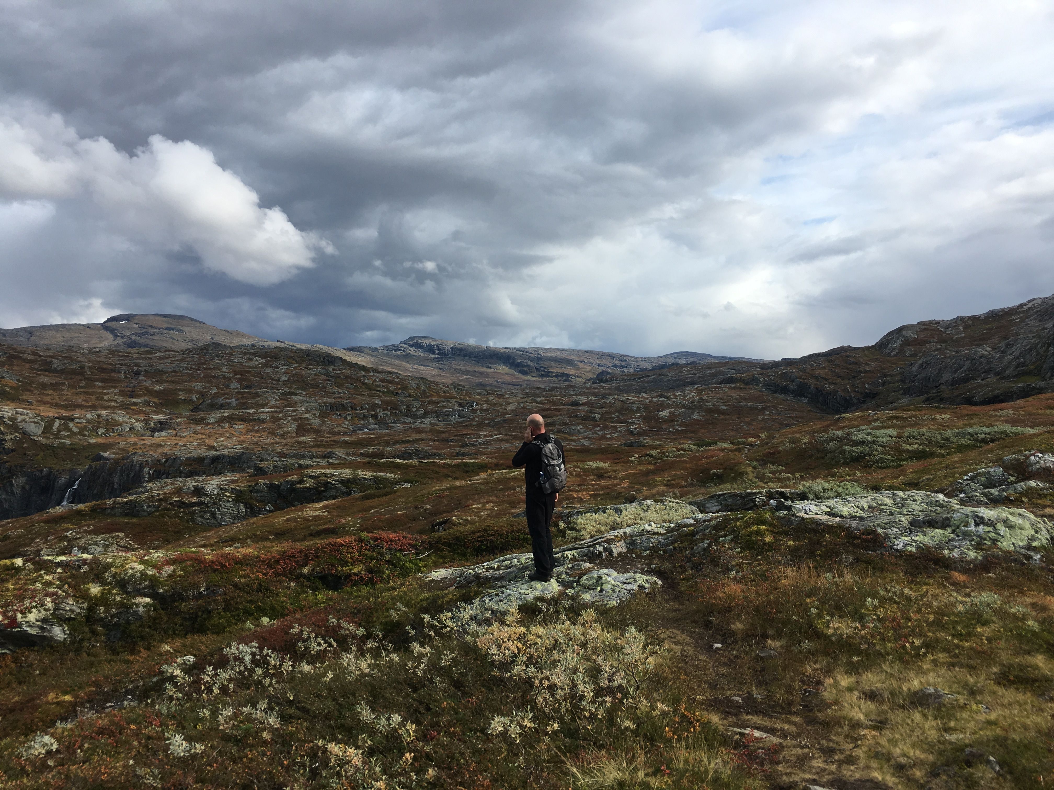 Hiker looking out across the vast mountain plateau of Hardangervidda.