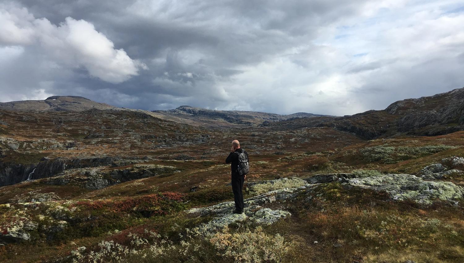 Hiker looking out across the vast mountain plateau of Hardangervidda.