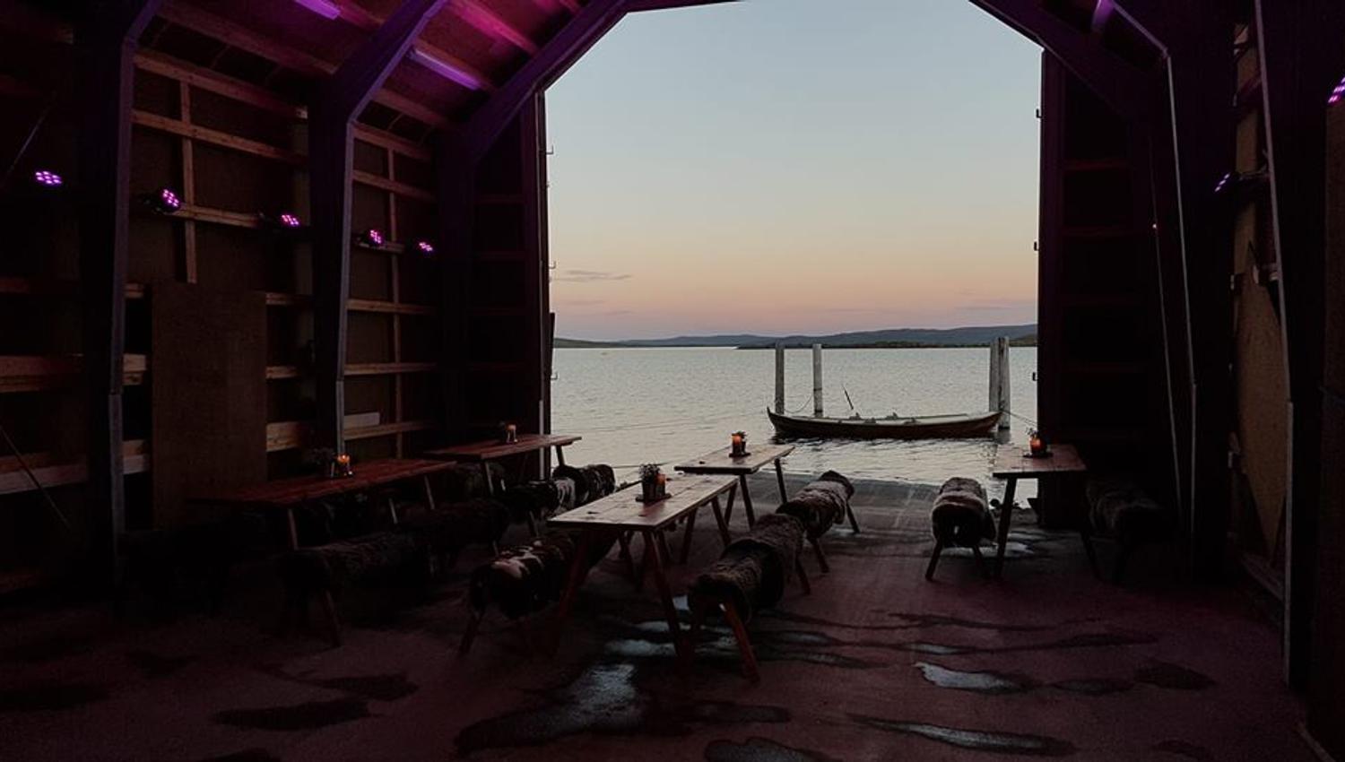 Utsyn fra et båthus på Halne, med rosa himmel i bakgrunnen.