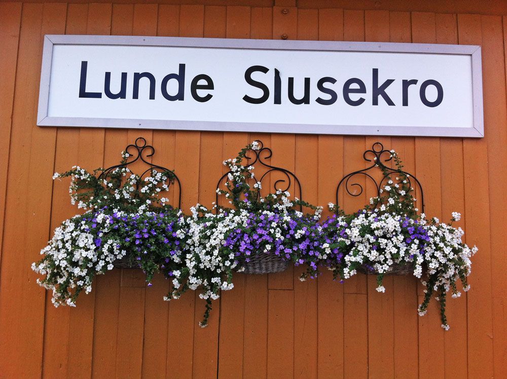 skilt til Lunde Slusekro med blomster under