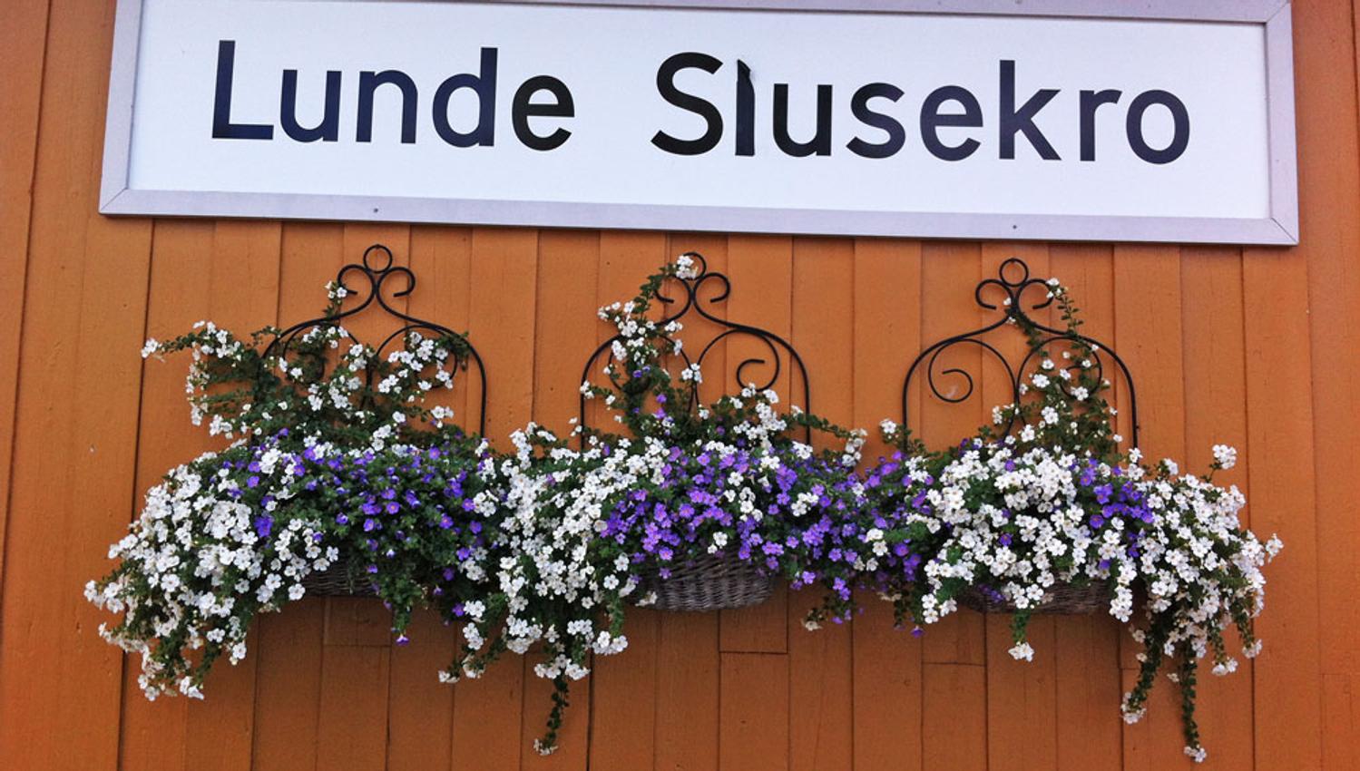 skilt til Lunde Slusekro med blomster under