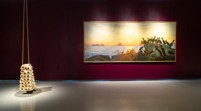 Stort maleri og utstilling som henger fra taket