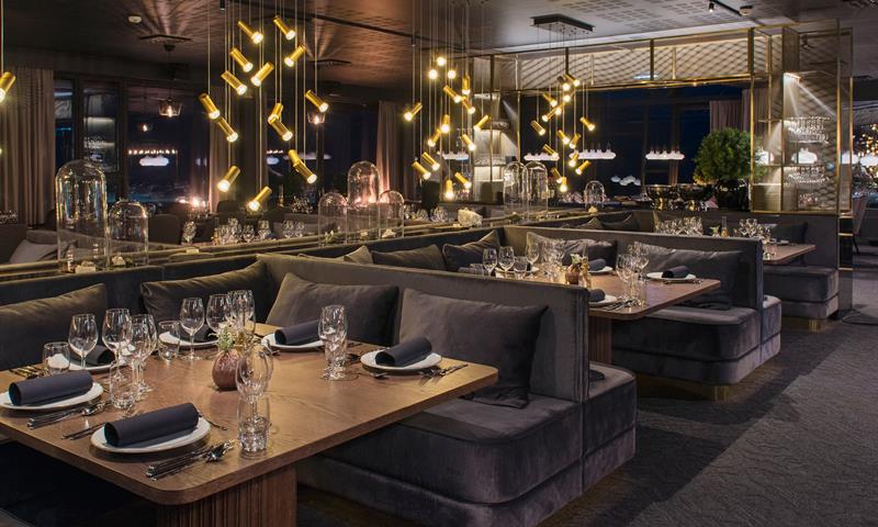 Et mørkt og koselig restaurantlokale med dekte bord