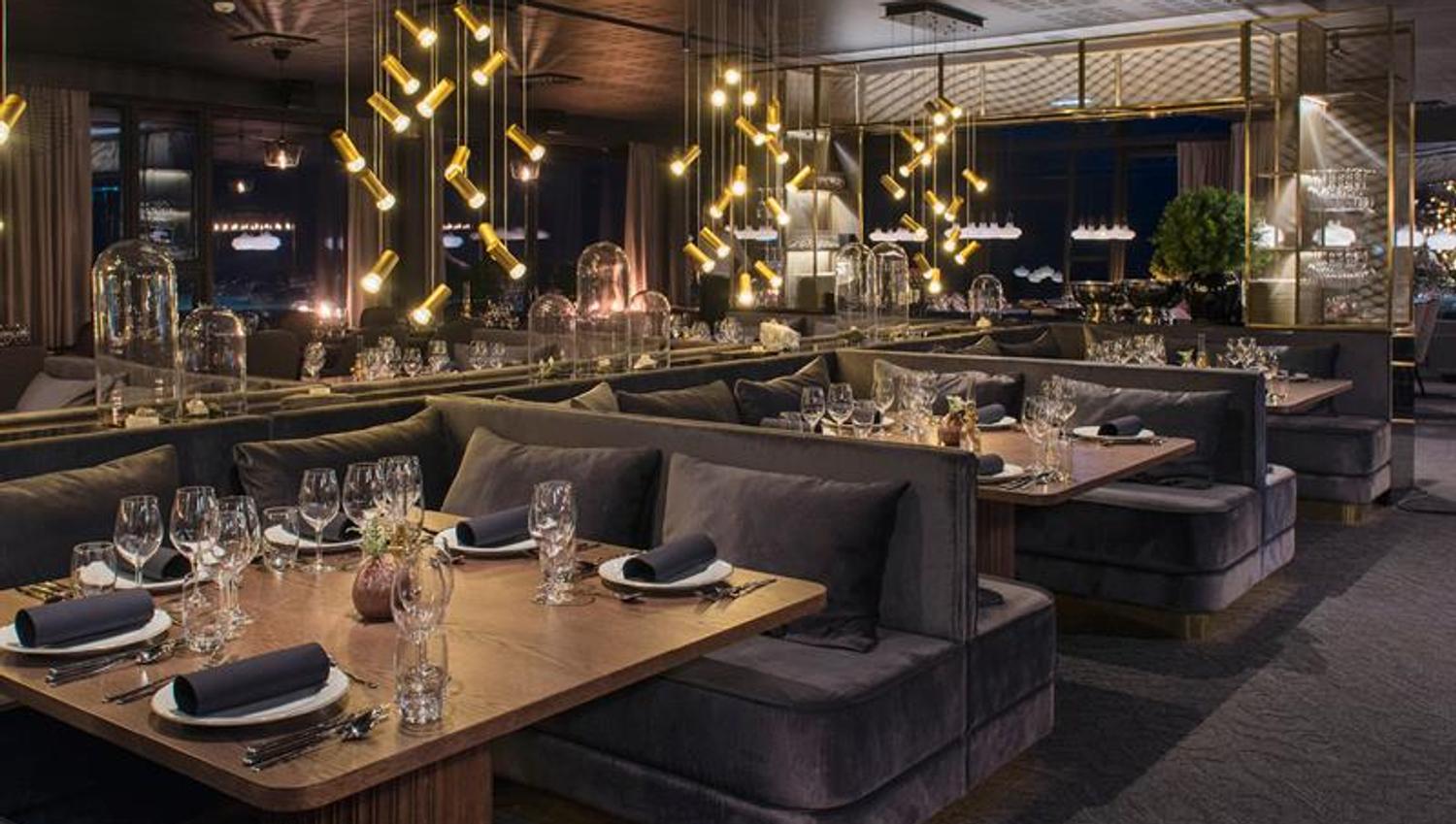 Et mørkt og koselig restaurantlokale med dekte bord