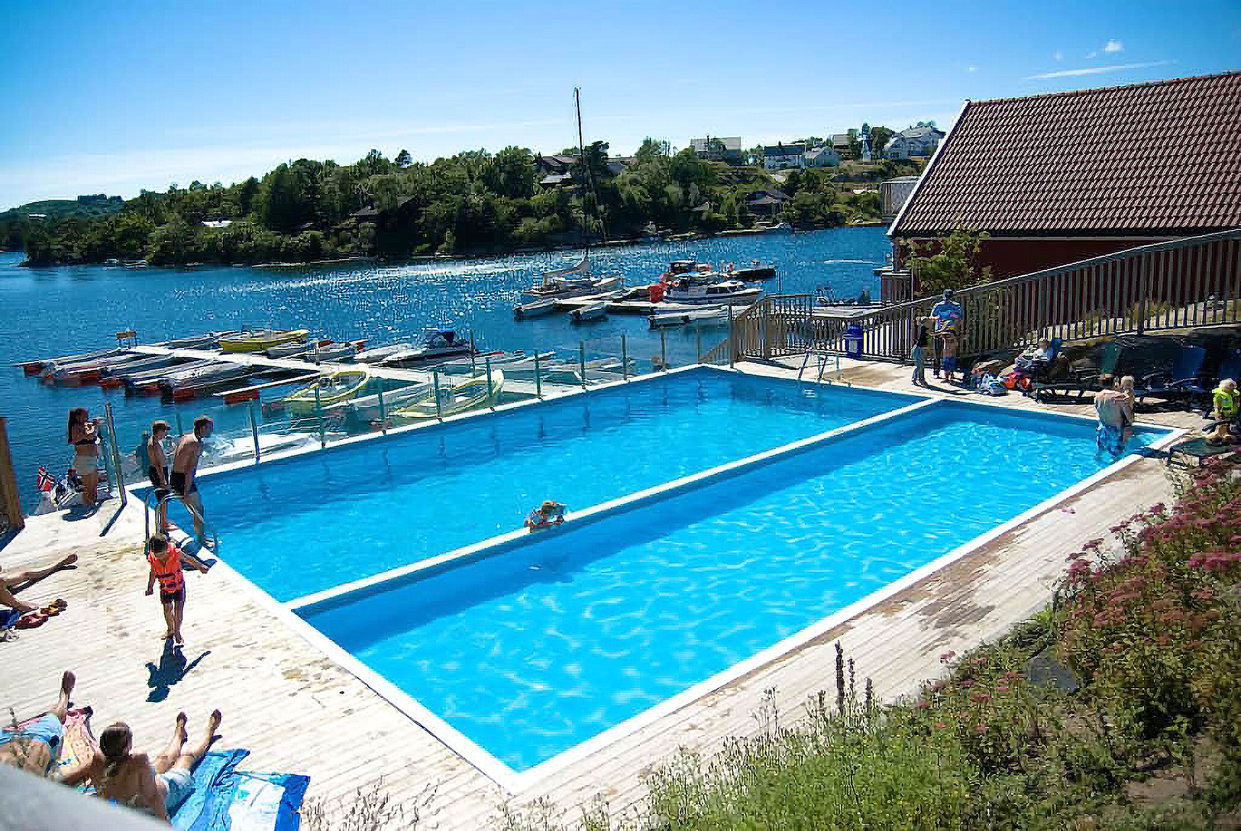 
Two swimming pools with people walking toward the pools