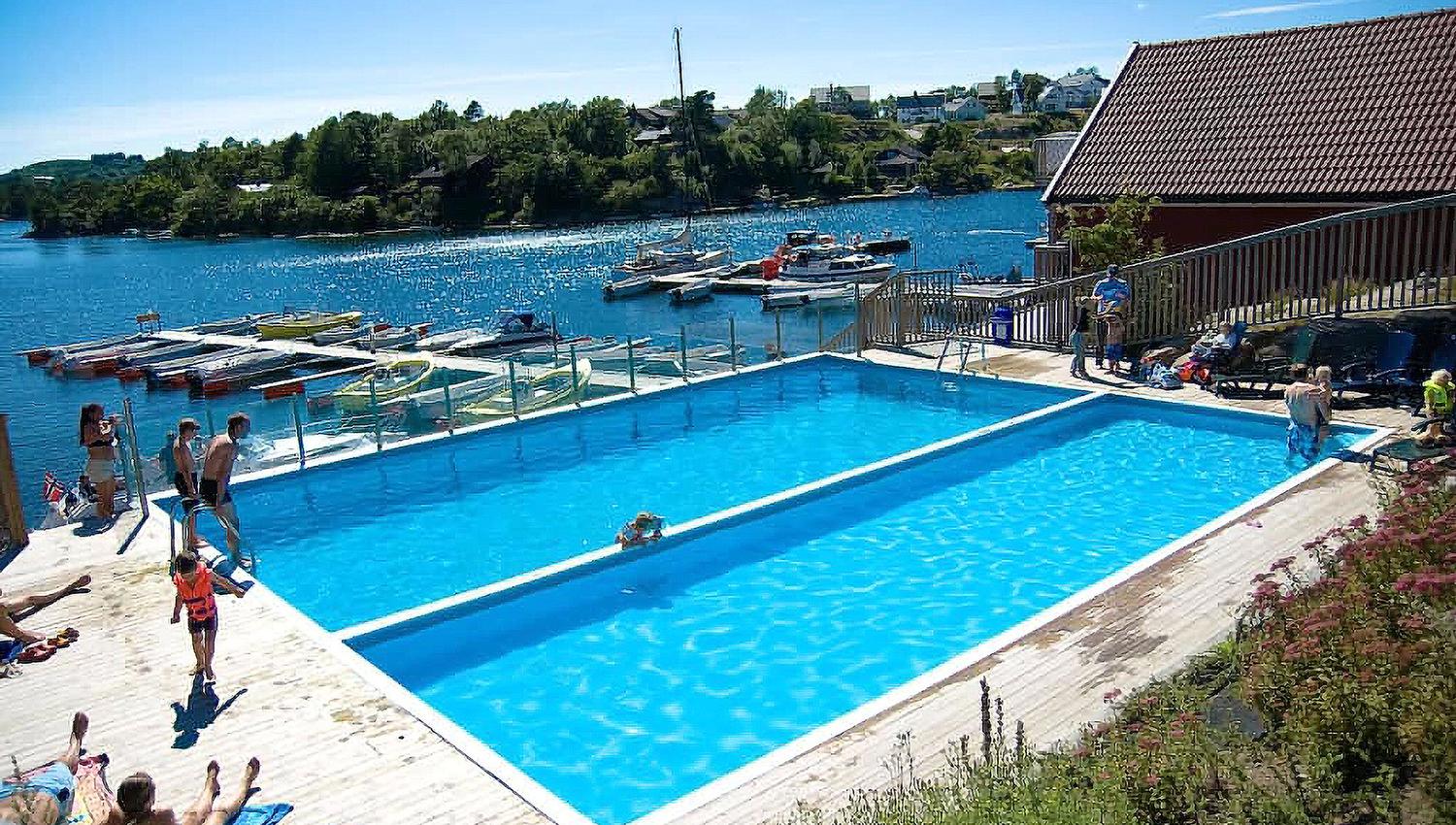 Two swimming pools with people walking toward the pools