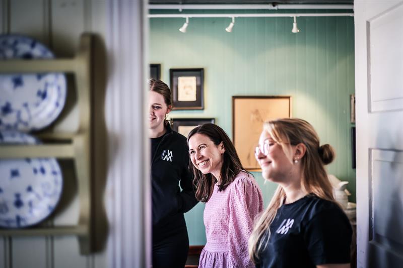 To ansette og en kunde smiler og ser på noe