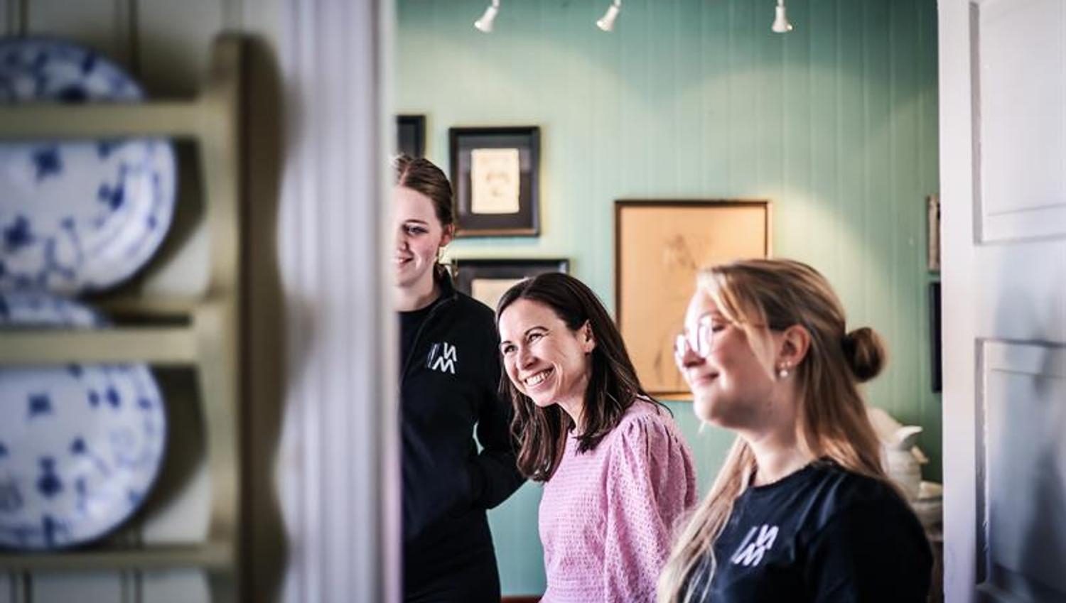 To ansette og en kunde smiler og ser på noe