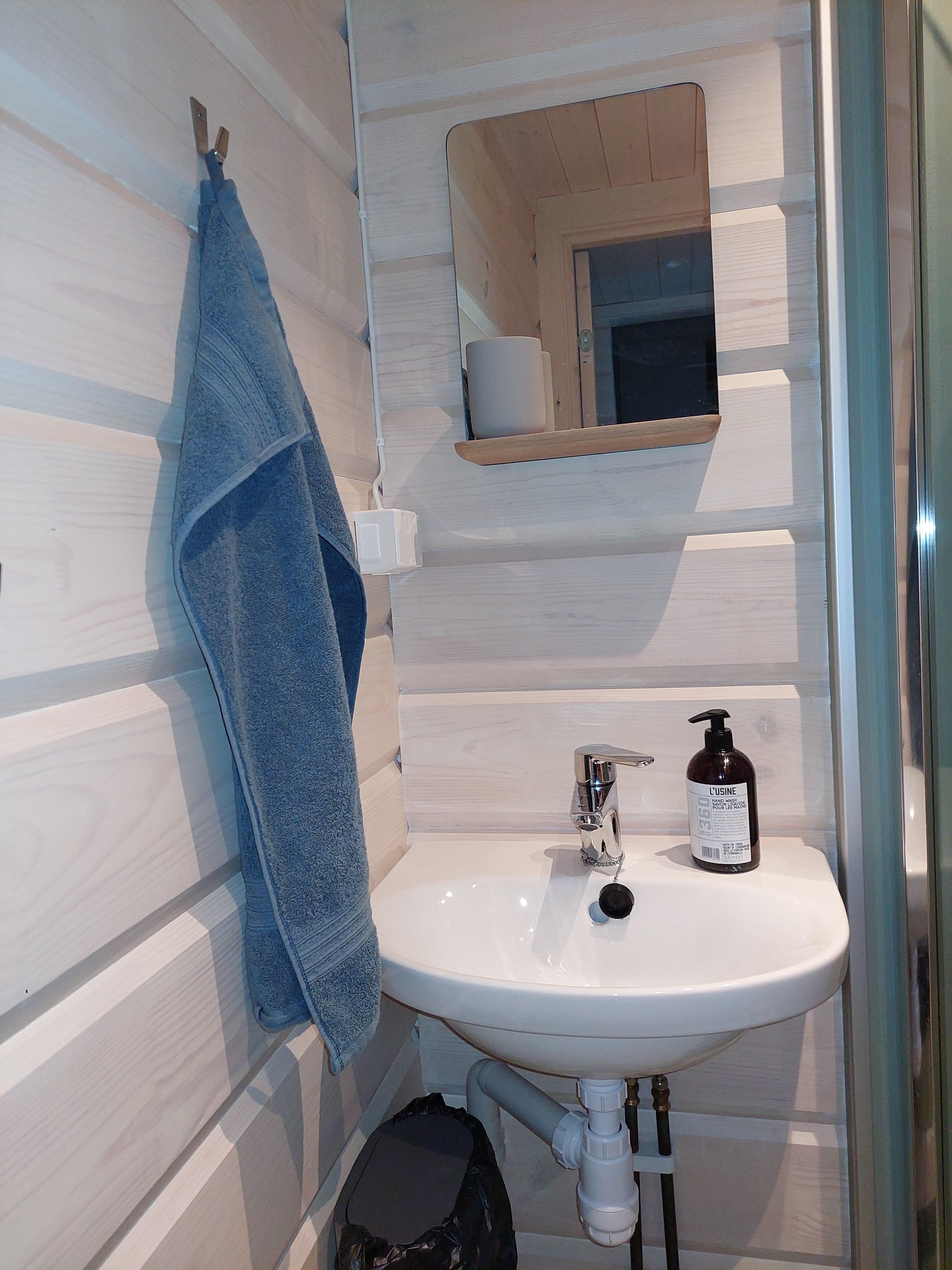 small room with mirror and a wash basin 