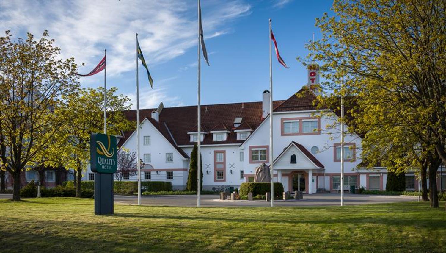 bilde av Quality hotel olavsgaard eksteriør, med de hvite veggene med rosa dekor i en sommergrønn hage