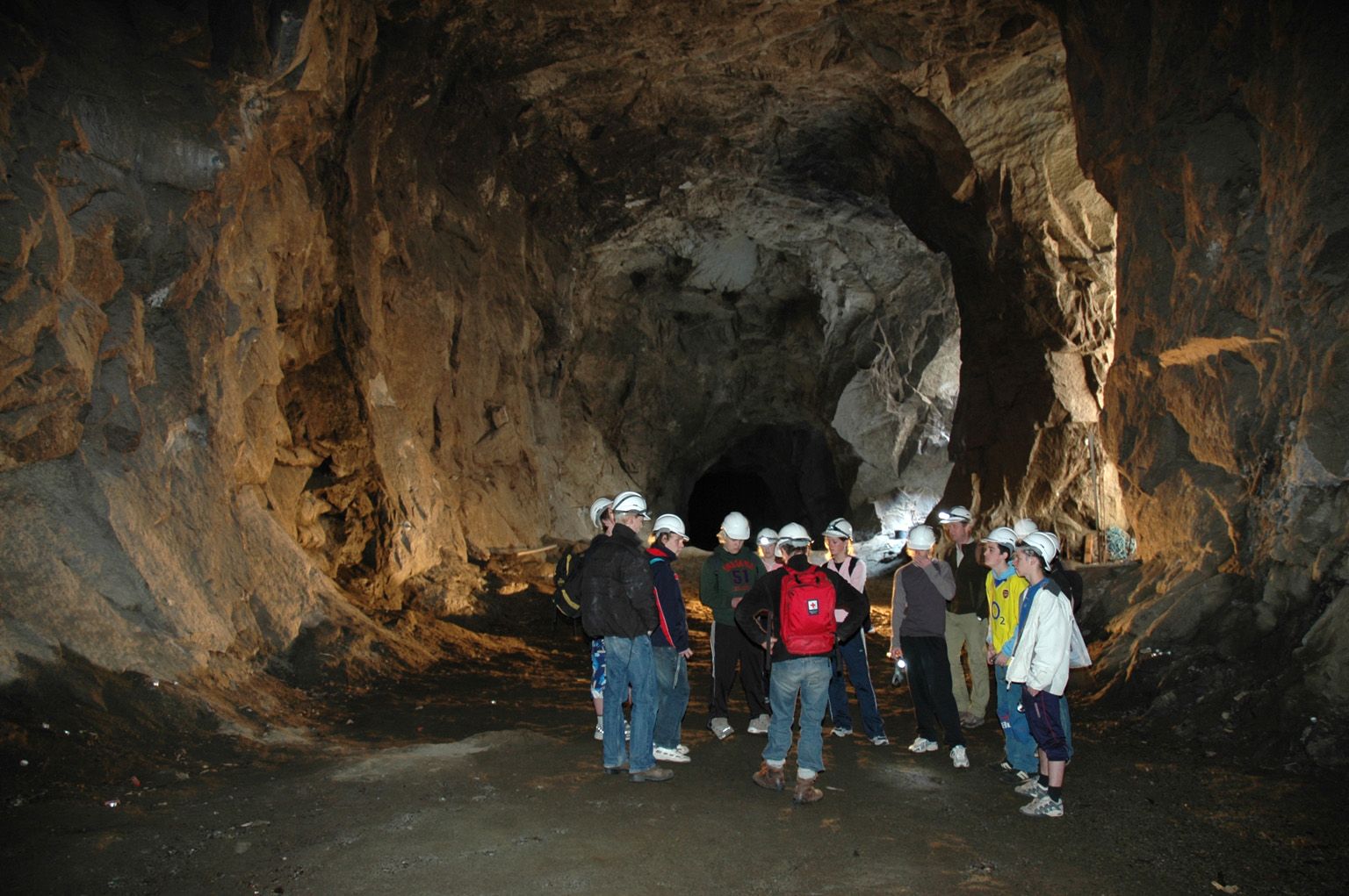 Ei gruppe besøkande på omvising inne i tunnelane på Lilletopp, der industrihistorie møter eventyr.